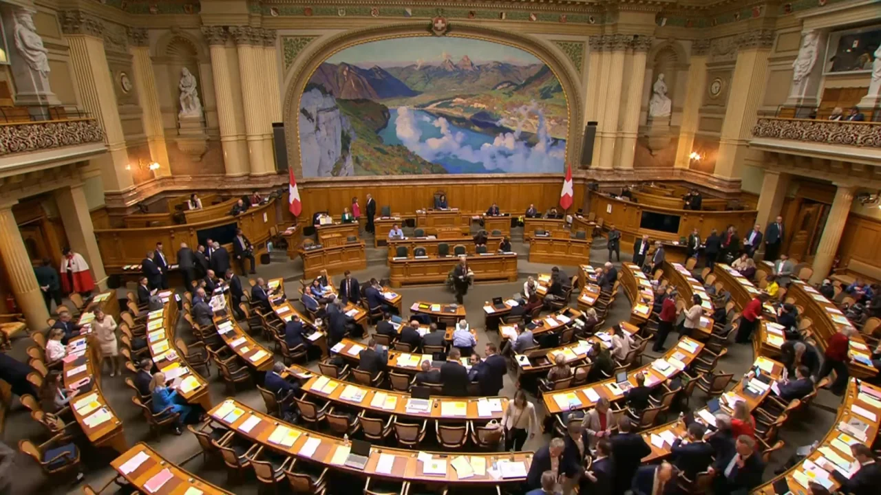 The parliamentary chamber as a setting for institutional activity. Video still: Swiss Federal Council, YouTube.